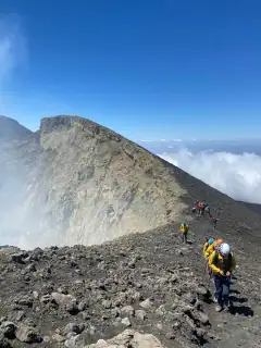 Hikers walking on the summit craters of Mount Etna
